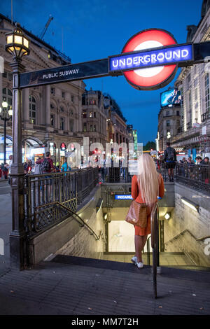 Frau außerhalb der Piccadilly Circus U-Bahn-Station Lonon UK stehend Stockfoto