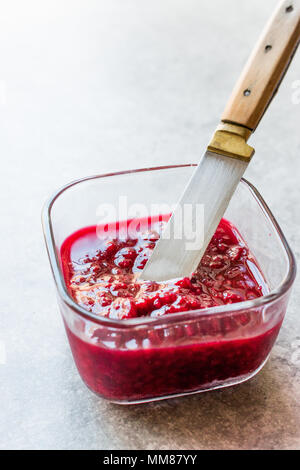 Himbeermarmelade mit Messer in Glasschale/Marmelade. Bio-frühstück. Stockfoto