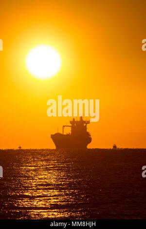 Eine offshore Frachter grüßt den Sonnenaufgang in der Nähe von Fort Lauderdale Beach in Südflorida. Stockfoto