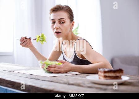 Hunger Frau am Kuchen suchen gedrückt Stockfoto