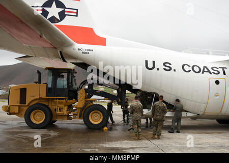 Lockheed Martin C-130 Hercules ist ein viermotoriges Turboprop-Transportflugzeug der United States Coast Guard. Das Archivbild dokumentiert die Entnahme von Notvorräten aus dem Flugzeug am Cyril E. King Airport in St. Thomas, US-Jungferninseln, am 14. September 2017, zur Unterstützung von Hurrikan Irma Hilfseinsätzen. Stockfoto