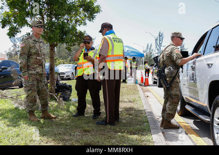 Oberstleutnant Daniel Walsh, der Kommandant der 1.BATAILLON, 128 Infanterie, 32nd Infantry Brigade Combat Team berät sich mit Beamten von Miami-Dade County Police Department und Sgt. Wade Blaylock, Team Leader mit Firma B, 1.BATAILLON, 128 Infanterie, führt Einlasskontrolle Operationen im südlichen Florida, Sept. 15. Service Mitglieder vom 1.BATAILLON, 128 Infanterie unterstützt die Miami-Dade PD und Florida Highway Patrol mit öffentlichen Sicherheit als Teil des Hurrikan Irma Hilfsaktionen. An Sept. 8, Wis. reg. Scott Walker unterzeichnet eine Ausführungsverordnung, der Adjutant gen zugelassen Stockfoto