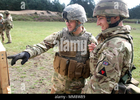 Sgt. Tanner Lewandowsky, ein Soldat mit Charlie Company, 1st Battalion, 125Th Infantry Regiment, zeigt einen Soldaten der Royal Wessex Yeomanry des Vereinigten Königreichs, in dem er auf sein Ziel, das während der US-Armee Alternative Qualifikation Kurs bei Sennelager Training Area, Deutschland, September 12, 2017. Die yeomanry nahmen an der Alternative Qualifikation Kurs, und fast jeder Soldat qualifiziert. (Michigan National Guard Foto: Staff Sgt. Brandon Ames) Stockfoto