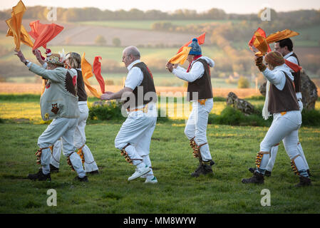 Rollright Stones, Nr Long Compton, Oxfordshire/Warwickshire, Großbritannien. 1. Mai 2018. Mitglieder der Owlswick Morris Seite Zuschauer bei Sonnenaufgang unterhalten Stockfoto