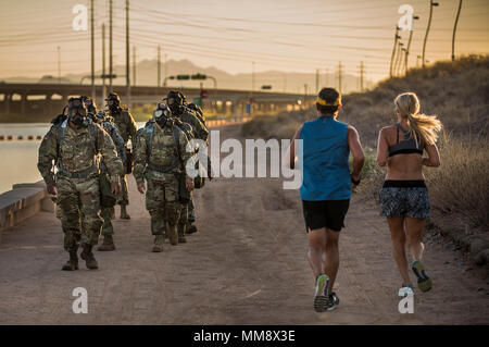 Jogger laufen hinter einer Gruppe von U.S. Army Reserve Command Sergeants Major von über 200 Militärpolizei Befehl in einem Team teilnehmen - Gebäude ruck März beim Tragen von Gasmasken während der Csm Huddle" in Scottsdale, Arizona, Sept. 16, 2017. Während der Unordnung, der Befehl Sergeants Major diskutiert wichtige Themen, die für ihren Auftrag und ihre Einheiten, um zu erhöhen die Bereitschaft zu implementieren. (U.S. Armee finden Foto von Master Sgt. Michel Sauret) Stockfoto