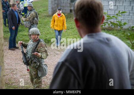 Sgt. Marc Stelter, Soldat mit Charlie Company (C Co.), 457Th zivilen Angelegenheiten Bataillon (CA MRD.), interagiert mit einer Rolle-Player während der Übung Cobra Strike 17 von C Co, 457Th CA BN, in Wackernheim, Deutschland, Sept. 16, 2017. Diese lokale multi-partnered Übung tests Bewertung Fähigkeiten zivile Angelegenheiten Lote' in einer fiktiven nach der Erdbebenkatastrophe Szenario und Abstimmung mit den örtlichen Rettungsdienst (U.S. Armee finden Foto vom Kapitän Jeku Arce, 221St Public Affairs Distanz). Stockfoto