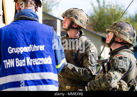 Soldaten mit Sanitätsstaffel Einsatz Einheit in Köln, Deutschland, Arbeit mit Mitgliedern der Bundesanstalt Technisches Hilfswerk Frankenthal, Deutschland, eine zivile Organisation, Such- und Rettungsmaßnahmen mit Koordinierung mit einem zivilen Angelegenheiten team von Charlie Company 457th zivilen Angelegenheiten Bataillons während der Übung Cobra Strike 17, Wackernheim, Deutschland, Sept. 16, 2017. Diese lokale multi-partnered Übung tests Bewertung Fähigkeiten zivile Angelegenheiten Lote' in einer fiktiven nach der Erdbebenkatastrophe Szenario und Abstimmung mit den örtlichen Rettungsdienst (U.S. Armee Finden phot Stockfoto