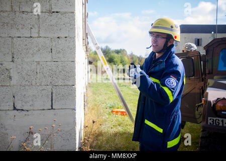 Ein Mitglied der Bundesanstalt Technisches Hilfswerk in Frankenthal, Deutschland, eine zivile Organisation, Durchführung von Such- und Rettungsaktionen mit Koordinierung mit einem zivilen Angelegenheiten team von Charlie Company 457th zivilen Angelegenheiten Bataillon während der Übung Cobra Strike 17, Wackernheim, Deutschland, Sept. 16, 2017. Diese lokale multi-partnered Übung tests Bewertung Fähigkeiten zivile Angelegenheiten Lote' in einer fiktiven nach der Erdbebenkatastrophe Szenario und Abstimmung mit den örtlichen Rettungsdienst (U.S. Armee finden Foto vom Kapitän Jeku Arce, 221St Public Affairs Distanz). Stockfoto