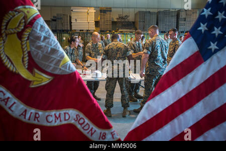 Us-Marines mit Marine Tactical Air Command Squadron 18 pass Kuchen Mitsoldaten während der 50-Jahr-Feier der MTACS-18 an Marine Corps Air Station Futenma, 15. September 2017. Während der Zeremonie, Marines lesen Auszüge über die mutigen Anstrengungen von MTACS-18. Die Staffel wurde am 1. September aktiviert, 1967 in Da Nang, Republik Vietnam, als Standort und Hauptsitz Squadron 18, Marine Air Control Gruppe 18, 1 Marine Flugzeugflügel. (U.S. Marine Corps Foto von Lance Cpl. Andy Martinez) Stockfoto