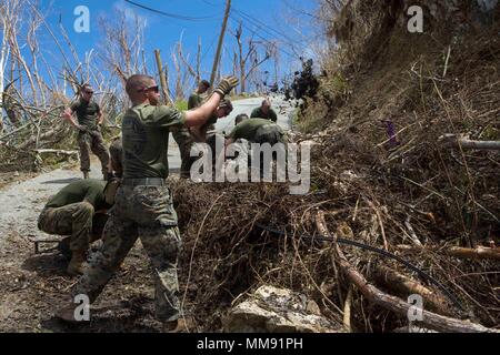 Us Marine Corps Pfc. Jameson E. Kovacs, ein mortarman mit Bataillon Landung Team 2 Bataillon, 6 Marine Regiment, 26 Marine Expeditionary Unit (MEU), wirft Schmutz von der Fahrbahn zu ermöglichen Fahrzeuge sicher in einer Gemeinschaft durch den Hurrikan Irma in St. John, US Virgin Islands, Sept. 17, 2017 betroffene zu navigieren. Die 26. MEU unterstützt Behörden in den U.S. Virgin Islands mit der kombinierten Ziel der Schutz des Lebens und der Sicherheit der Personen in den betroffenen Gebieten. (U.S. Marine Corps Foto von Lance Cpl. Santino D. Martinez) Stockfoto