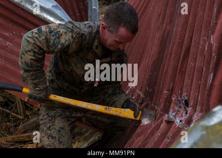 Us Marine Corps Sgt. Austin C Morgan, eine assaultman mit Bataillon Landung Team 2 Bataillon, 6 Marine Regiment, 26 Marine Expeditionary Unit (MEU), verwendet eine Axt um Rückstände an einem lokalen Brand Station, die durch Hurrikan Irma in St. John, US Virgin Islands, Sept. 17, 2017 betroffen war. Die 26. MEU unterstützt Behörden in den U.S. Virgin Islands mit der kombinierten Ziel der Schutz des Lebens und der Sicherheit der Personen in den betroffenen Gebieten. (U.S. Marine Corps Foto von Lance Cpl. Santino D. Martinez) Stockfoto