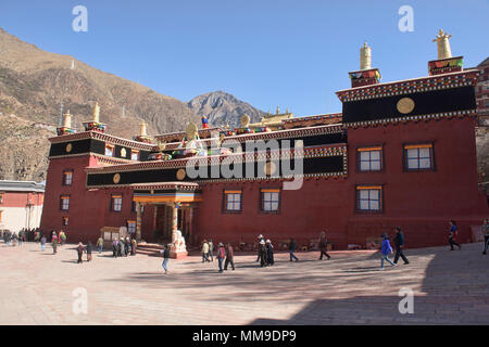 Tibetischen Pilger wandern Kora Kreise um den heiligen Bakong Schrift Druckmaschine Kloster in Dege, Sichuan, China Stockfoto