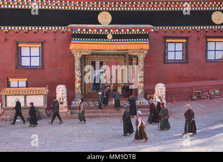 Tibetischen Pilger wandern Kora Kreise um den heiligen Bakong Schrift Druckmaschine Kloster in Dege, Sichuan, China Stockfoto