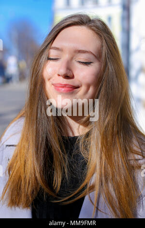 Nahaufnahme Gesicht der hübschen Frau zu Fuß in der Stadt im grauen Mantel. Stockfoto