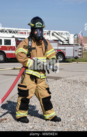 Mitglieder der Tulsa Feuerwehr Durchführung von Schulungen mit einem full-size Flugzeugbrand Trainingsgerät Sept. 13, 2017, Tinker Air Force Base, Oklahoma. Die Tulsa Feuerwehrmänner waren Gäste der 72nd Bauingenieur Squadron, Feuerwehr, die Rezertifizierung unterzogen wurde. (U.S. Air Force Foto/Greg L. Davis) Stockfoto