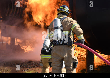 Mitglieder der Tulsa Feuerwehr Durchführung von Schulungen mit einem full-size Flugzeugbrand Trainingsgerät Sept. 13, 2017, Tinker Air Force Base, Oklahoma. Die Tulsa Feuerwehrmänner waren Gäste der 72nd Bauingenieur Squadron, Feuerwehr, die Rezertifizierung unterzogen wurde. (U.S. Air Force Foto/Greg L. Davis) Stockfoto