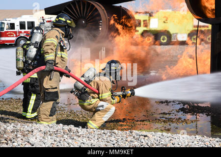 Mitglieder der Tulsa Feuerwehr Durchführung von Schulungen mit einem full-size Flugzeugbrand Trainingsgerät Sept. 13, 2017, Tinker Air Force Base, Oklahoma. Die Tulsa Feuerwehrmänner waren Gäste der 72nd Bauingenieur Squadron, Feuerwehr, die Rezertifizierung unterzogen wurde. (U.S. Air Force Foto/Greg L. Davis) Stockfoto