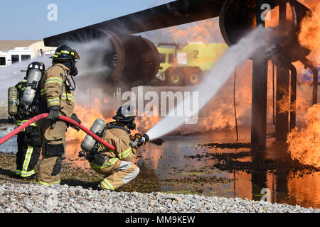 Mitglieder der Tulsa Feuerwehr Durchführung von Schulungen mit einem full-size Flugzeugbrand Trainingsgerät Sept. 13, 2017, Tinker Air Force Base, Oklahoma. Die Tulsa Feuerwehrmänner waren Gäste der 72nd Bauingenieur Squadron, Feuerwehr, die Rezertifizierung unterzogen wurde. (U.S. Air Force Foto/Greg L. Davis) Stockfoto