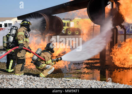 Mitglieder der Tulsa Feuerwehr Durchführung von Schulungen mit einem full-size Flugzeugbrand Trainingsgerät Sept. 13, 2017, Tinker Air Force Base, Oklahoma. Die Tulsa Feuerwehrmänner waren Gäste der 72nd Bauingenieur Squadron, Feuerwehr, die Rezertifizierung unterzogen wurde. (U.S. Air Force Foto/Greg L. Davis) Stockfoto