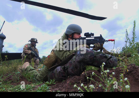 Slowenische Armee Pvt. Gregor Jurkivsek von CBRNE Slowenien zieht Sicherheit nach dem Verlassen einer UH-60 Black Hawk, während auf einem kombinierten Mission mit der 1. Staffel, 91st Cavalry Regiment, 173Rd Airborne Brigade, bei einem Luftangriff auf Adazi, Lettland am 19. September 2017 arbeitet. Die slowenische Armee arbeitet an der Seite ihrer NATO-Verbündeten als Teil des Bajonett Schild, einer Region, die weit in den Baltischen Ländern internationale Teamarbeit in realistischen Übungen zwischen den USA und ihren NATO-Verbündeten und Partnern, einschließlich ihrer verstärkten Präsenz weiterleiten Ba zu verbessern Stockfoto