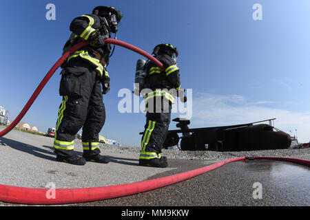 Zwei Mitgliedstaaten Teams aus dem 72. Bauingenieur Squadron, Feuerwehr, zusammen arbeiten, wie Sie das Flugzeug Feuer Trainingsgerät Sept. 13, 2017 Ansatz, Tinker Air Force Base, Oklahoma. Die Feuerwehrleute waren Durchführung jährlicher Rezertifizierung in der realistischen Umgebung. (U.S. Air Force Foto/Greg L. Davis) Stockfoto