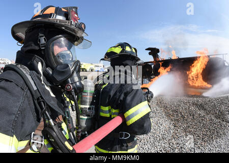 Zwei Mitgliedstaaten Teams aus dem 72. Bauingenieur Squadron, Feuerwehr, zusammen arbeiten, wie Sie das Flugzeug Feuer Trainingsgerät Sept. 13, 2017 Ansatz, Tinker Air Force Base, Oklahoma. Die Feuerwehrleute waren Durchführung jährlicher Rezertifizierung in der realistischen Umgebung. (U.S. Air Force Foto/Greg L. Davis) Stockfoto