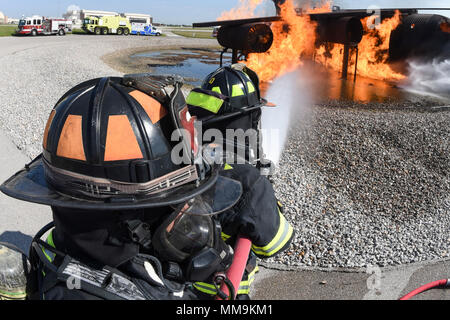 Zwei Mitgliedstaaten Teams aus dem 72. Bauingenieur Squadron, Feuerwehr, zusammen arbeiten, wie Sie das Flugzeug Feuer Trainingsgerät Sept. 13, 2017 Ansatz, Tinker Air Force Base, Oklahoma. Die Feuerwehrleute waren Durchführung jährlicher Rezertifizierung in der realistischen Umgebung. (U.S. Air Force Foto/Greg L. Davis) Stockfoto