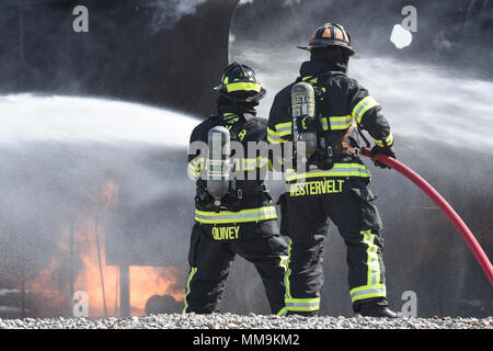 Zwei Mitgliedstaaten Teams aus dem 72. Bauingenieur Squadron, Feuerwehr, zusammen arbeiten, wie Sie das Flugzeug Feuer Trainingsgerät Sept. 13, 2017 Ansatz, Tinker Air Force Base, Oklahoma. Die Feuerwehrleute waren Durchführung jährlicher Rezertifizierung in der realistischen Umgebung. (U.S. Air Force Foto/Greg L. Davis) Stockfoto