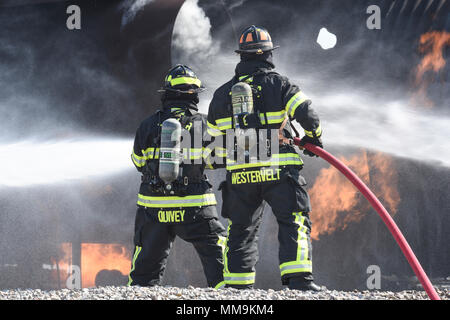 Zwei Mitgliedstaaten Teams aus dem 72. Bauingenieur Squadron, Feuerwehr, zusammen arbeiten, wie Sie das Flugzeug Feuer Trainingsgerät Sept. 13, 2017 Ansatz, Tinker Air Force Base, Oklahoma. Die Feuerwehrleute waren Durchführung jährlicher Rezertifizierung in der realistischen Umgebung. (U.S. Air Force Foto/Greg L. Davis) Stockfoto