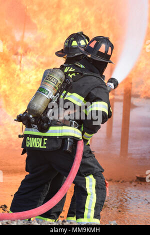 Zwei Mitgliedstaaten Teams aus dem 72. Bauingenieur Squadron, Feuerwehr, zusammen arbeiten, wie Sie das Flugzeug Feuer Trainingsgerät Sept. 13, 2017 Ansatz, Tinker Air Force Base, Oklahoma. Die Feuerwehrleute waren Durchführung jährlicher Rezertifizierung in der realistischen Umgebung. (U.S. Air Force Foto/Greg L. Davis) Stockfoto