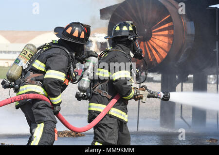 Zwei Mitgliedstaaten Teams aus dem 72. Bauingenieur Squadron, Feuerwehr, zusammen arbeiten, wie Sie das Flugzeug Feuer Trainingsgerät Sept. 13, 2017 Ansatz, Tinker Air Force Base, Oklahoma. Die Feuerwehrleute waren Durchführung jährlicher Rezertifizierung in der realistischen Umgebung. (U.S. Air Force Foto/Greg L. Davis) Stockfoto