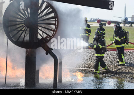 Zwei Mitgliedstaaten Teams aus dem 72. Bauingenieur Squadron, Feuerwehr, zusammen arbeiten, wie Sie das Flugzeug Feuer Trainingsgerät Sept. 13, 2017 Ansatz, Tinker Air Force Base, Oklahoma. Die Feuerwehrleute waren Durchführung jährlicher Rezertifizierung in der realistischen Umgebung. (U.S. Air Force Foto/Greg L. Davis) Stockfoto