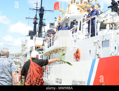 Leighton Tseu, Kane O Ke Kai, gibt einen Hawaiianischen Segen bei der Ankunft der Coast Guard Cutter Oliver Berry (WPC 1124) bei Coast Guard Base Honolulu, Sept. 22, 2017. Die Oliver Berry ist die erste von drei 154-Fuß-schnelle Reaktion Fräser in Hawaii stationiert. (U.S. Coast Guard Foto von Petty Officer 2. Klasse Tara Molle/Freigegeben) Stockfoto