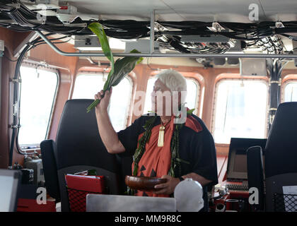 Leighton Tseu, Kane O Ke Kai, gibt einen Hawaiianischen Segen bei der Ankunft der Coast Guard Cutter Oliver Berry (WPC 1124) bei Coast Guard Base Honolulu, Sept. 22, 2017. Diese Fräser mit der verbesserten Wirksamkeit bei Such- und Rettungsdiensten wird die Gewässer um die Inseln von Hawaii viel sicherer Ort für Freizeitboote und Nutzer der Wasserstraße. (U.S. Coast Guard Foto von Petty Officer 2. Klasse Tara Molle/Freigegeben) Stockfoto