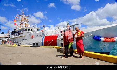 Leighton Tseu, Kane o ke Kai, und Richard 'Baby' Bell, Pu-Kane, stehen für ein Foto nach Segen Coast Guard Cutter Oliver Berry (WPC 1124) Nach Ihrer Ankunft in Honolulu Sept. 22, 2017. Dies ist der erste von drei schnelle Reaktion Fräser nach Hawaii zu kommen. (U.S. Coast Guard Foto von Chief Petty Officer Sara Muir/Freigegeben) Stockfoto