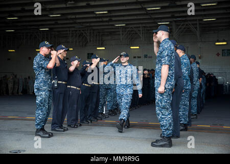 170922-N-OS 895-0068 Norfolk, Virginia (Sept. 22, 2017) Hospital Corpsman 3. Klasse Timothy McBride liefert die begrüßt der USS Gerald R. Ford (CVN 78) Segler, als er das Schiff fährt. (U.S. Marine Foto von Mass Communication Specialist 2. Klasse Jason Pastrick) Stockfoto