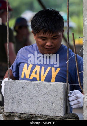 Philippinische Marine FN2 Elvis Julius legt einen Stein auf eine Wand der Küche bei Esperanza Grundschule zur Unterstützung der KAMANDAG in Casiguran, Aurora, Philippinen, Sept. 22, 2017. Bilaterale Übungen wie KAMANDAG erhöhen die Fähigkeit der Vereinigten Staaten und den Philippinen zu schnell reagieren und gemeinsam während der realen Welt terroristische oder humanitären Krisen, um die Mission zu erfüllen, die Unterstützung der lokalen Bevölkerung und menschliches Leid zu mindern. (U.S. Marine Corps Foto von Lance Cpl. Tiana Boyd) Stockfoto