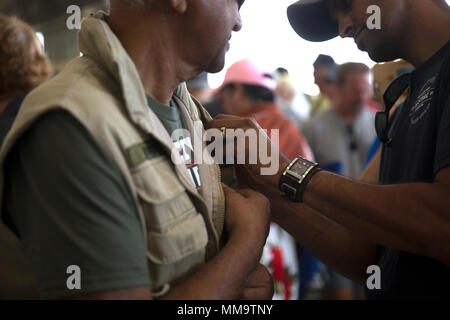 Ein Sohn schenkt eine ehrennadel zu seinem Vater seinen Dienst während des Vietnam Krieges zu erkennen, während einer pinning Preisverleihung auf der Marine Corps Air Station Miramar Air Show 2017 auf der MCAS Miramar, Calif., Sept. 22. "Die 2017 MCAS Miramar Air Show gibt der Öffentlichkeit und aktuelle Service Mitglieder Gelegenheit, Danke zu sagen zu den Veteranen des Vietnamkriegs", sagte Oberst Jason Woodworth, kommandierender Offizier der MCAS Miramar. "Unser Ziel ist es, die Veteranen, die das Land um Sie kümmert sich wirklich Werte zu erinnern und der Opfer, die sie für das amerikanische Volk gemacht, unabhängig davon, wie sie behandelt wurden, wenn sie erste Stockfoto