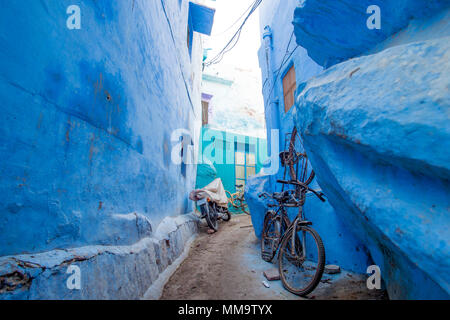 Ein Fahrrad- und ein Motorrad in einer kleinen Gasse in die blaue Stadt Jodhpur, Rajasthan, Indien. Stockfoto
