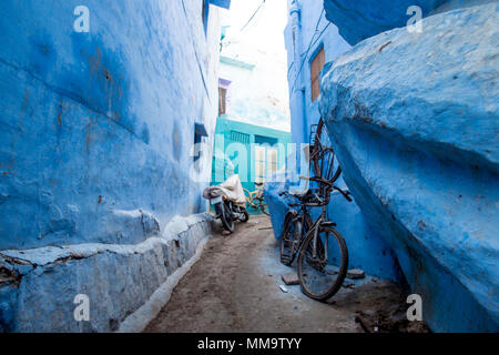 Ein Fahrrad- und ein Motorrad in einer kleinen Gasse in die blaue Stadt Jodhpur, Rajasthan, Indien. Stockfoto