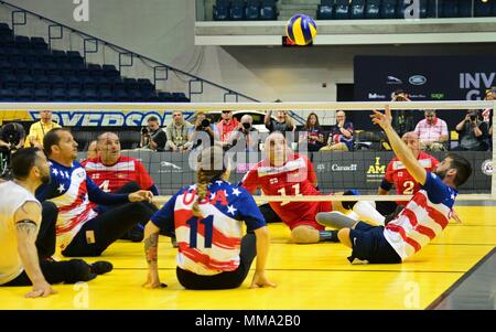 U.S. Army veteran Stefan Leroy, ein ehemaliger Sergeant und Mitglied von Team USA, fällt zurück, als er den Ball für Mannschaftskameraden während der Sitzung volleyball Endspiele an die 2017 Invictus Spiele in der Mattamy Athletic Center in Toronto, Kanada, Sept. 27, 2017. Leroy wurde verletzt, als eine improvisierte Sprengkörper gezündet. Juni 7, 2012, wodurch ihm beide Beine zu verlieren. (U.S. Air Force Foto: Staff Sgt. Alexx Pons) Stockfoto