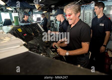 170926-N-KW 492-040 karibische Meer (bis 30. 26, 2017) Geraldo Rivera mans das Ruder auf der Brücke der Amphibisches Schiff USS Kearsarge (LHD3) bei einem Besuch in das Schiff, die Crew und die Führung zu treffen. Kearsarge unterstützt mit Hilfsmaßnahmen in den Wirbelsturm Maria. Das Verteidigungsministerium ist die Unterstützung von FEMA, die Leitung der Föderalen Agentur, dabei helfen, die Betroffenen durch den Hurrikan Maria Leiden zu minimieren und ist ein Bestandteil der gesamten-von-Reaktion seitens der Regierung. (U.S. Marine Foto von Mass Communication Specialist 3. Klasse Ryre Arciaga/Freigegeben) Stockfoto