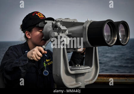 170926-N-UY 653-028 OSTSEE (Sept. 26, 2017) Lt. j.g. Jeanette Moutray scannt den Horizont mit dem Fernglas an Bord der Arleigh-Burke-Klasse geführte Anti-raketen-Zerstörer USS Oscar Austin (DDG79) Sept. 26, 2017. Oscar Austin auf einer routinemäßigen Bereitstellung unterstützen die nationale Sicherheit der USA Interessen in Europa und der zunehmenden Theater Sicherheit gute Zusammenarbeit und freuen uns naval Präsenz in den USA 6 Flotte Bereich der Operationen. (U.S. Marine Foto von Mass Communication Specialist 2. Klasse Ryan Utah Kledzik/Freigegeben) Stockfoto