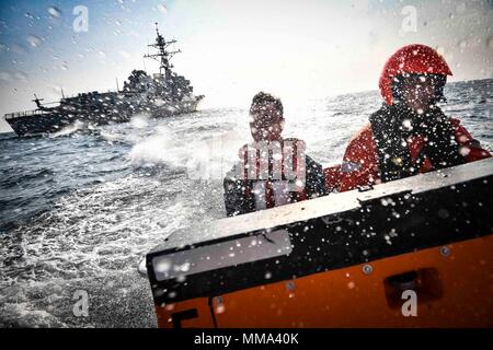 170926-N-UY 653-096 OSTSEE (Sept. 26, 2017) Schwedische Segler auf die schwedische Marine Visby zugewiesen-Klasse corvette HSwMS Karlsand (K35) Transfer Matrosen der Arleigh-Burke-Klasse geführte Anti-raketen-Zerstörer USS Oscar Austin (DDG79) von Oscar Austin zu Karlsand, Sept. 26, 2017. Oscar Austin auf einer routinemäßigen Bereitstellung unterstützen die nationale Sicherheit der USA Interessen in Europa und der zunehmenden Theater Sicherheit gute Zusammenarbeit und freuen uns naval Präsenz in den USA 6 Flotte Bereich der Operationen. (U.S. Marine Foto von Mass Communication Specialist 2. Klasse Ryan Utah Kledzik/Freigegeben) Stockfoto