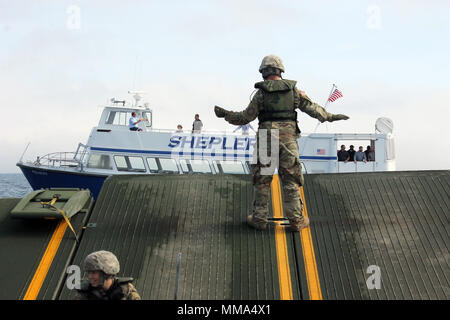 Die Soldaten an Bord eines 130 Fuß verbesserte Ribbon Bridge von der Michigan National Guard 1437th Multi-Role Brücke Unternehmen, und das Personal an Bord einer Fähre Shepler® Boot arbeiten zusammen, um während des Betriebs Shining Star, Sept. 23, 2017. OSS ist ein Emergency Management Übung in den Straßen von Mackinac, die zusammen bringt auf Bundes-, Landes- gemeinschaft und zivile Teilnehmer Soforthilfemaßnahmen zu proben. (Michigan National Guard Foto von Scott Martzke) Stockfoto