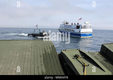 Die Soldaten an Bord eines 130 Fuß ribbon Bridge von der Michigan National Guard 1437th Multi-Role Brücke Unternehmen und Personal an Bord einer Fähre Shepler® Boot arbeiten zusammen, um während des Betriebs Shining Star, Sept. 23, 2017. OSS ist ein Emergency Management Übung in den Straßen von Mackinac, die zusammen bringt auf Bundes-, Landes- gemeinschaft und zivile Teilnehmer Soforthilfemaßnahmen zu proben. (Michigan National Guard Foto von Scott Martzke) Stockfoto