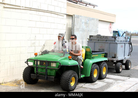 Airman 1st Class Pedro Pedraza und Staff Sgt. Carlos Arroyo reisen mit einem Generator Lage an Muniz Air National Guard Base, Oktober 1, 2017. Die beiden Piloten sind Mitglieder der Puerto Rico Air National Guard und arbeiten daran, die Generatoren an der Air Base am Laufen zu halten. Der Puerto Rico Air National Guard arbeitet mit vielen Bundes- und lokalen Agenturen in Reaktion auf die Beschädigung von Puerto Rico durch Hurrikan Maria, der die Insel Gebiet an Sept. 20, 2017 Hit verursacht. (U.S. Air National Guard Foto von Tech. Sgt. Dan Heaton) Stockfoto