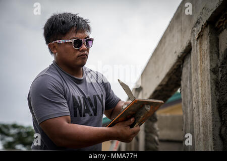 Philippinische Marine FN2 Elvis Julius Lufthutzen konkrete Stuck der Seite eines Gebäudes während KAMANDAG Bau Operations bei Esperanza Volksschule in Casiguran, Aurora, Philippinen, Sept. 28, 2017. Bilaterale Übungen wie KAMANDAG erhöhen die Fähigkeit der Vereinigten Staaten und den Philippinen zu schnell reagieren und gemeinsam während der realen Welt terroristische oder humanitären Krisen, um die Mission zu erfüllen, die Unterstützung der lokalen Bevölkerung und menschliches Leid zu mindern. Julius ist mit 4 Service Support Bataillon, und ist ein Eingeborener von Tinoc, Ifugao, Philippinen. (U.S. Marine Co Stockfoto