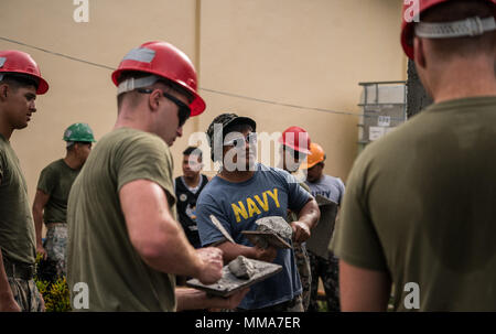 Philippinische Marine FN2 Elvis Julius gilt Stuckarbeiten an der Wand eines Gebäudes neben US-Marines bei Bauarbeiten am Esperanza Grundschule zur Unterstützung der KAMANDAG in Casiguran, Aurora, Philippinen, 01.10.2017. KAMANDAG ist ein Akronym für die Philippinischen Phrase "Kaagapay Ng Mga Mandirigma Ng Dagat", was übersetzt "Zusammenarbeit von Kriegern des Meeres", der Partnerschaft zwischen der Philippinischen und United States Militärs hervor. Julius ist mit 4 Service Support Bataillon, und ist ein Eingeborener von Tinoc, Ifugao, Philippinen. (U.S. Marine Corps Foto von Sgt. Matthew J. Bragg) Stockfoto