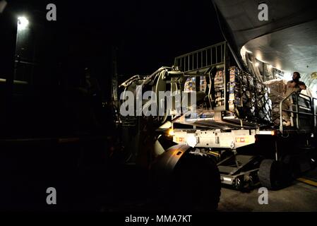 Die 3d-Luftbrücke der Squadron erreichen 7170 Crew und 123 Contingency Response Group Flieger entladen Essen und Wasser aus einem C-17 Globemaster III der Hurrikan Überlebenden von San Juan Luis Muñoz Marín Flughafen in San Juan, Puerto Rico verteilt werden, an Sept. 30, 2017. Reach 7170 gelieferten 118 tausend Pfund von Mahlzeiten bereit zu Essen und Mineralwasser in einem verwüsteten Puerto Rico mit Hilfe der Flieger aus der 123 Contingency Response Group verteilt werden. (U.S. Air Force Foto von Tech. Sgt. Matt Davis) Stockfoto